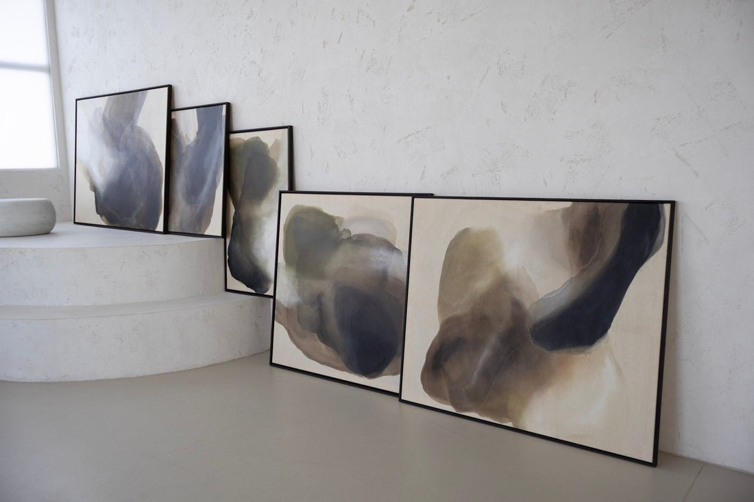 New abstract art collection Before the Light Touches by Studio Liv Olsen — a series of large, nature-inspired paintings in earthy tones, leaning side by side against a studio wall, capturing light, texture, and quiet atmosphere."